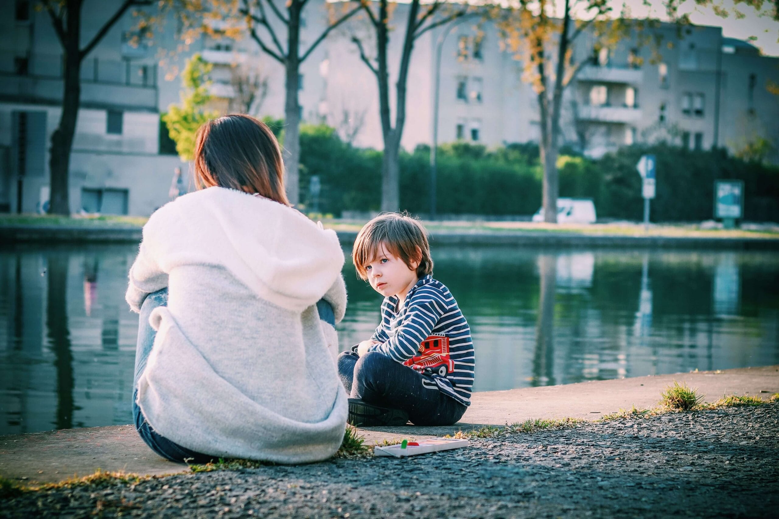 Vrouw en kind zitten aan het water